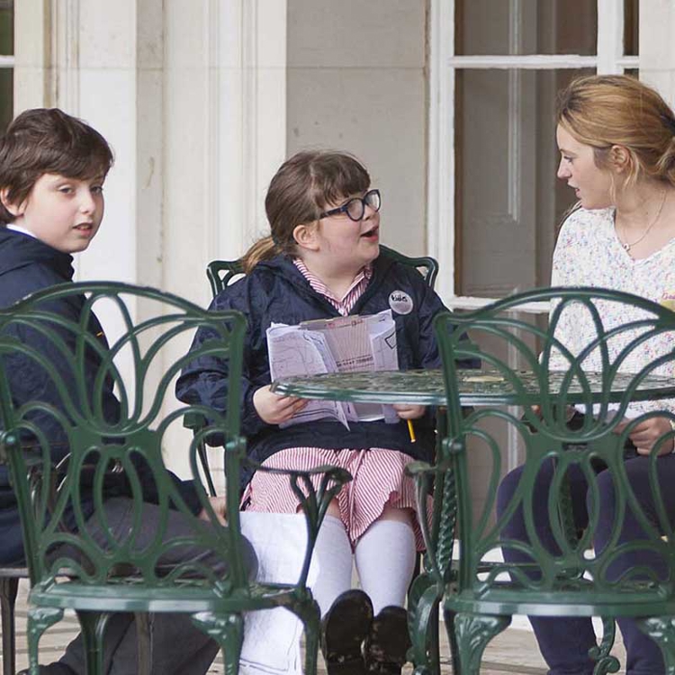 Children and an adult sitting around a table outside